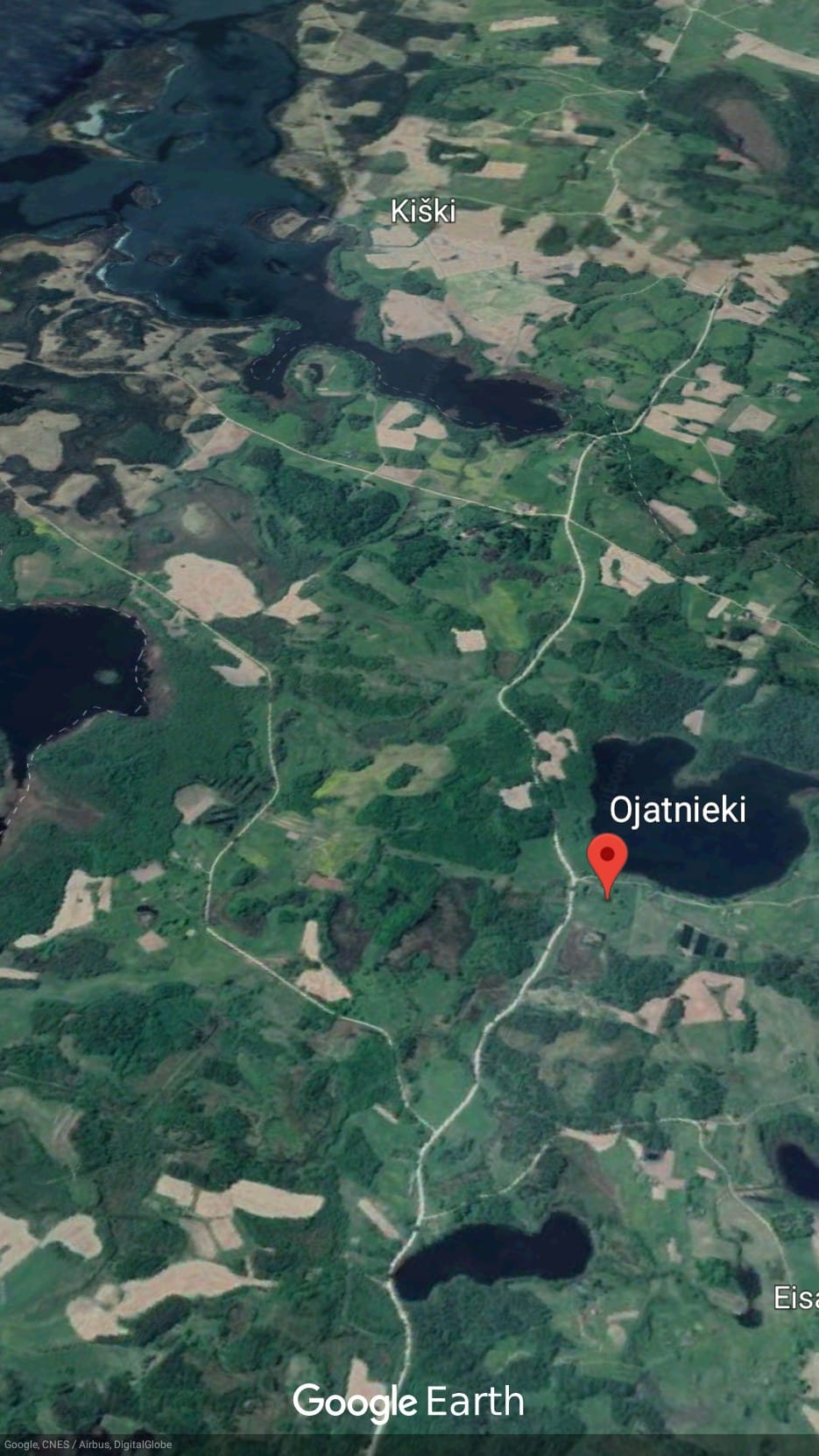 Zeme ar ēkām ezera krastā